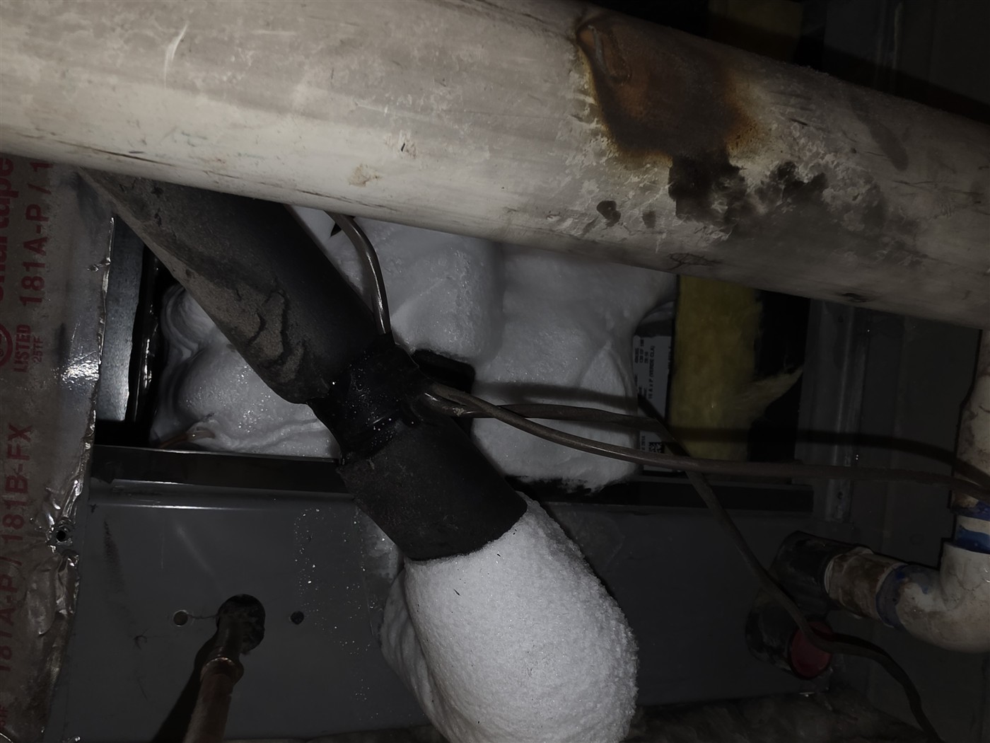 A refrigerant line frozen solid with ice