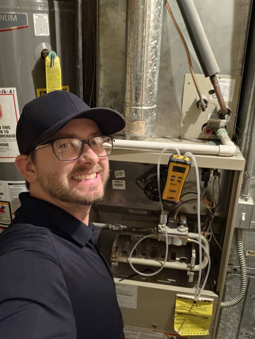 Devan, owner of Canyon Comfort, performing a furnace tune-up
